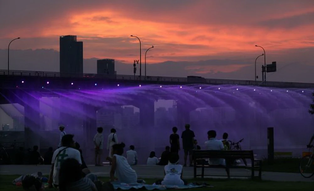 Người dân hóng mát dưới đài phun nước ở cầu Banpo, Seoul tối 15/8. (Nguồn: The Korea Times)