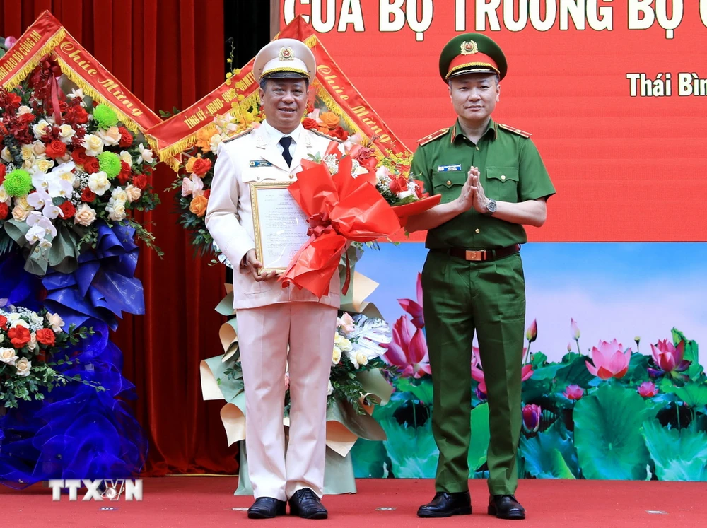 Thiếu tướng Nguyễn Ngọc Lâm, Thứ trưởng Bộ Công an trao quyết định của Bộ trưởng Bộ Công an cho Đại tá Trần Xuân Ánh. (Ảnh: Thế Duyệt/TTXVN)