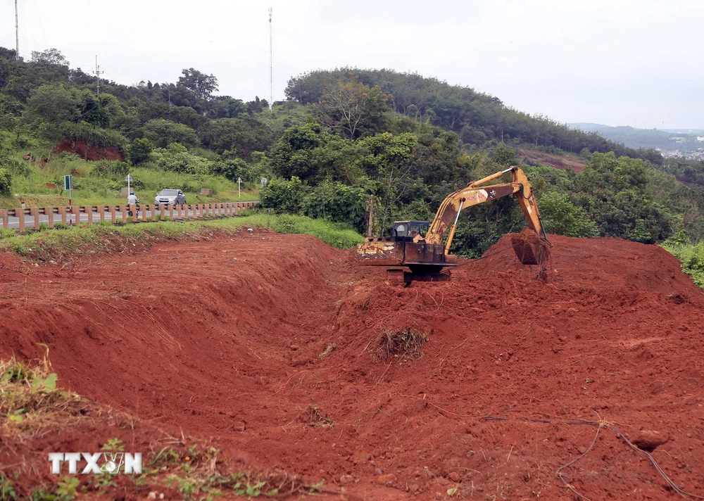 Máy múc san gạt, di chuyển các khối đất để bảo vệ hành lang đường Hồ Chí Minh. (Ảnh: Hưng Thịnh/TTXVN)