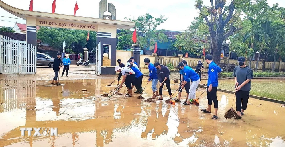 Các đội hình thanh niên tình nguyện xung kích, hỗ trợ các điểm trường trên địa bàn huyện Quảng Ninh, tỉnh Quảng Bình dọn vệ sinh sau mưa, lũ. (Ảnh: TTXVN phát)