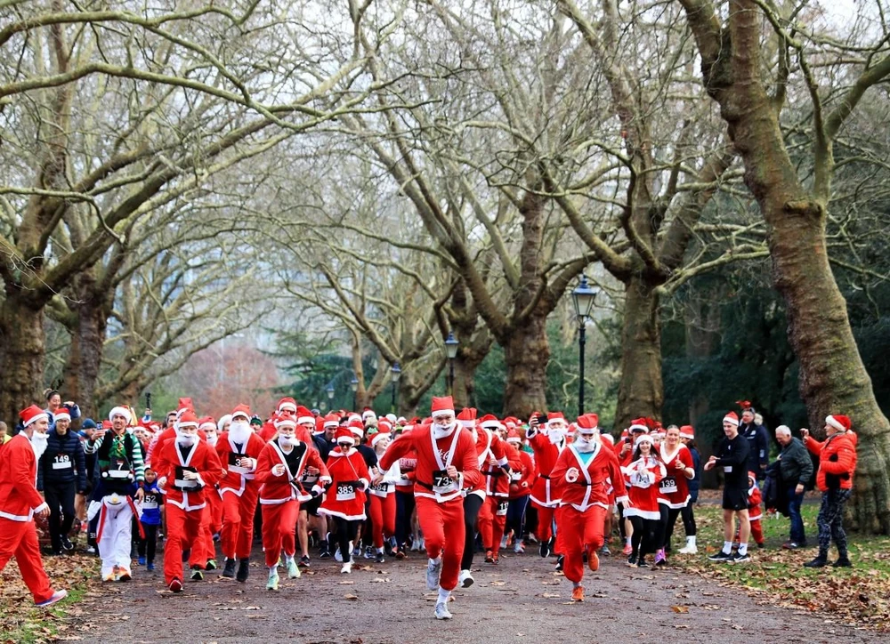 Người dân tham gia cuộc thi chạy Ông già Noel ở London, Anh. (Ảnh: THX/TTXVN)