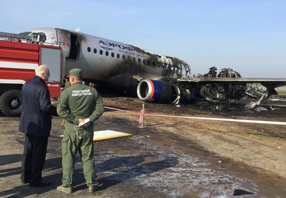 Lực lượng chức năng điều tra tại hiện trường máy bay Sukhoi Superjet 100 của Aeroflot bị phá hủy sau vụ cháy. (Ảnh: AFP/TTXVN)