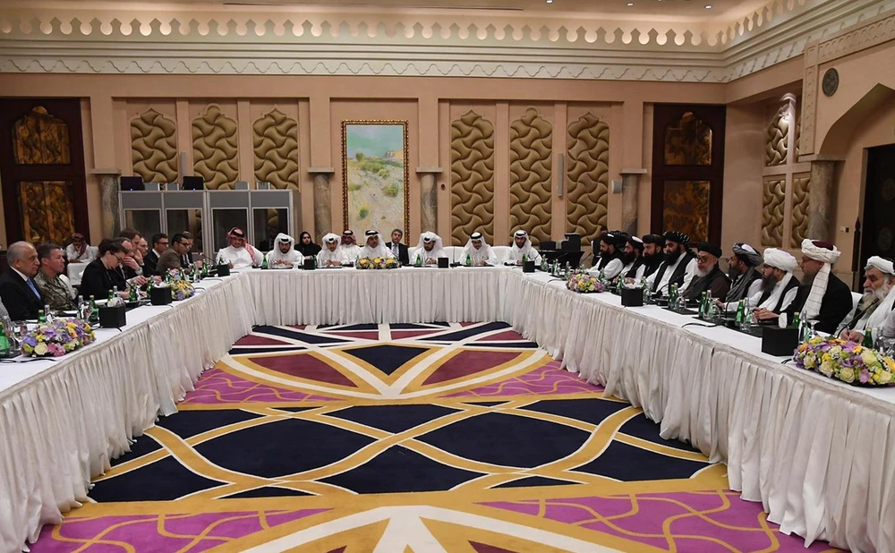 Phái đoàn Mỹ (trái) và phái đoàn Taliban (phải) tại vòng đàm phán hòa bình ở Doha, Qatar ngày 26/2. (Ảnh: AFP/TTXVN)