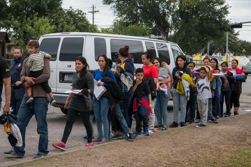 Người di cư Trung Mỹ tới khu tạm trú của một tổ chức từ thiện sau khi được thả từ cơ sở giam giữ những người chưa được cấp quy chế tị nạn tại McAllen,Texas, Mỹ. (Ảnh: AFP/ TTXVN)