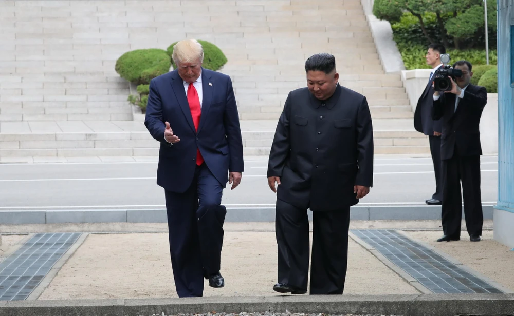 Tổng thống Mỹ Donald Trump (trái) và nhà lãnh đạo Triều Tiên Kim Jong-un (phải) bất ngờ gặp lại nhau tại DMZ hôm 30/6. (Ảnh: THX/TTXVN)