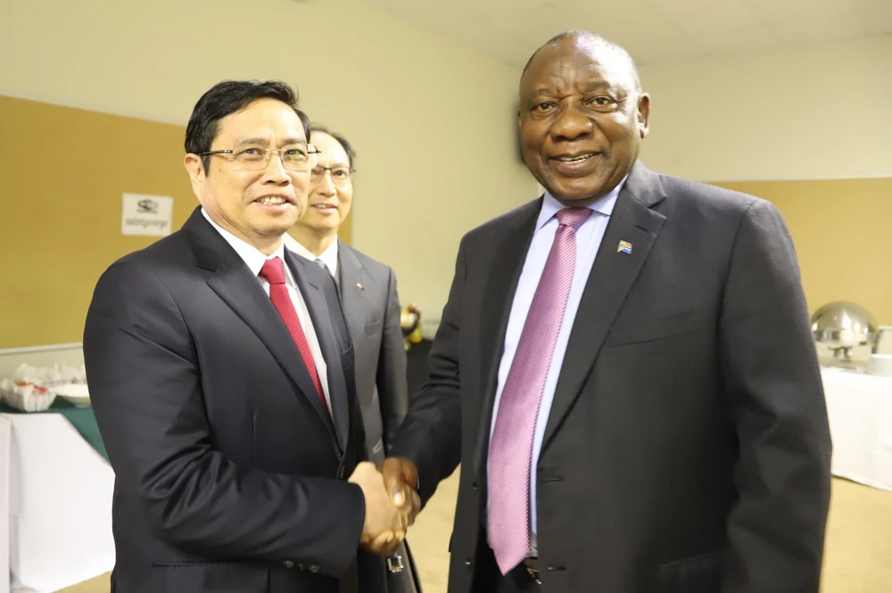 Chủ tịch Đảng Đại hội Dân tộc Phi (ANC) Cyril Ramaphosa đón chào đồng chí Phạm Minh Chính tại thủ đô Pretoria. (Ảnh: Phi Hùng/TTXVN)