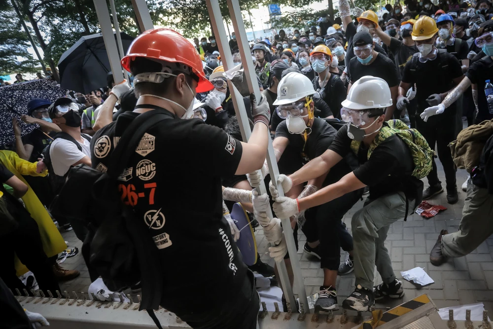 Những người biểu tình quá khích phá hàng rào để tràn vào tòa nhà cơ quan lập pháp ở Hong Kong, Trung Quốc, ngày 1/7. (Ảnh: AFP/TTXVN)