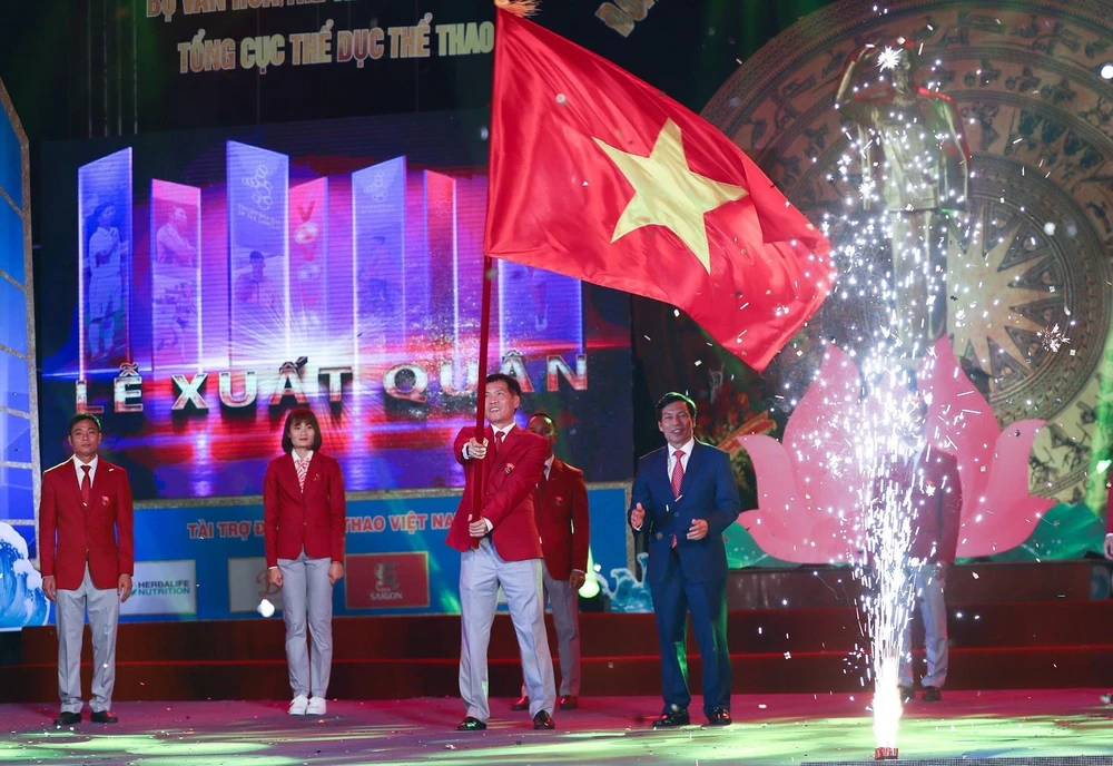 Ông Trần Đức Phấn, Phó Tổng cục trưởng Tổng cục Thể dục thể thao, Trưởng Đoàn thể thao Việt Nam tham dự SEA Games 30 phất cao lá quốc kỳ Việt Nam trong Lễ xuất quân. (Ảnh: Trọng Đạt/TTXVN)
