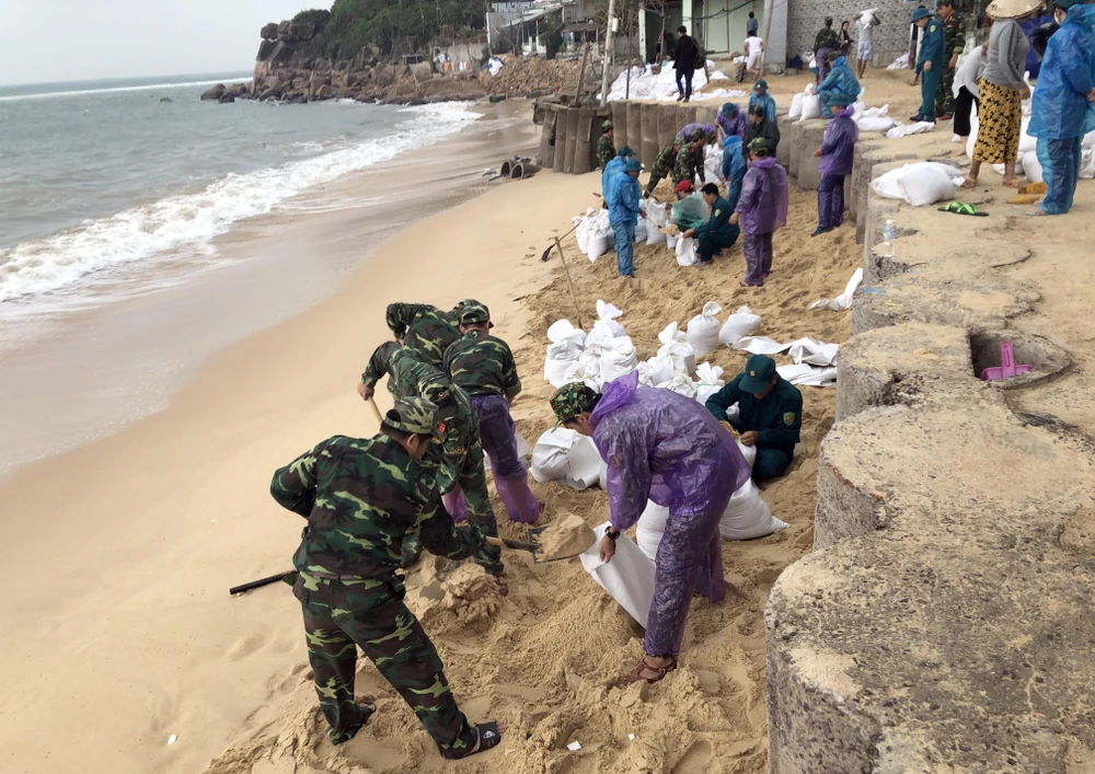 Lực lượng vũ trang tại tỉnh Bình Định xúc cát giúp người dân xã Nhơn Hải, TP Quy Nhơn gia cố nhà cửa chống bão số 6. (Ảnh: Nguyên Linh -TTXVN)