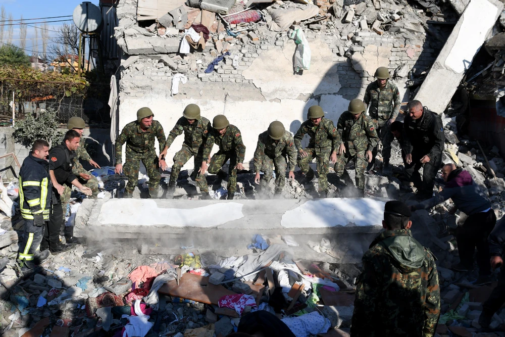 Nhân viên cứu hộ tìm kiếm nạn nhân dưới những đống đổ nát sau trận động đất ở Thumane, Albania. (Ảnh: AFP/TTXVN)