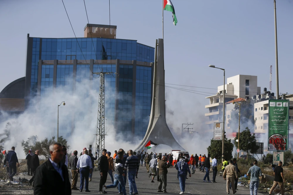 Người dân Palestine xung đột với các lực lượng an ninh Israel trong cuộc biểu tình tại thành phố Ramallah, Bờ Tây. (Ảnh: AFP/TTXVN)