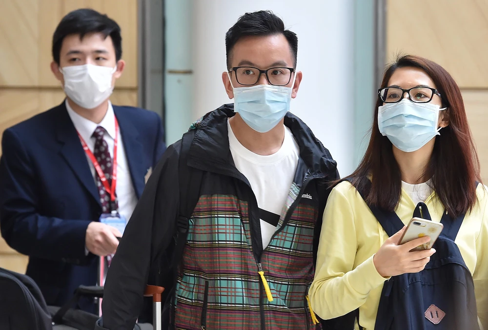 Hành khách đeo khẩu trang phòng dịch viêm phổi do virus corona. (Ảnh: AFP/TTXVN)