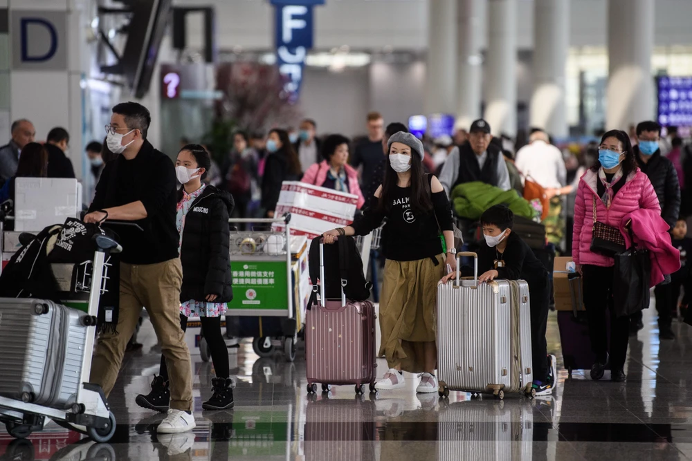 Hành khách đeo khẩu trang để phòng tránh lây nhiễm virus corona tại sân bay quốc tế Hong Kong. (Ảnh: AFP/TTXVN)
