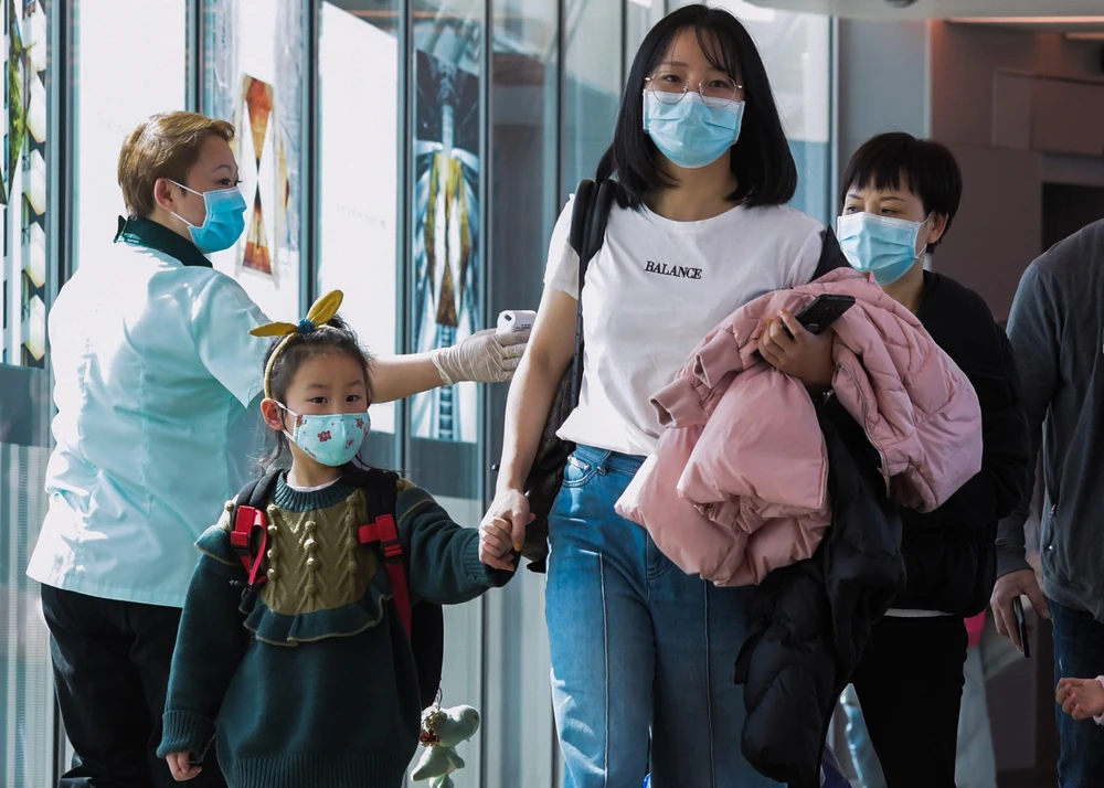 Hành khách đeo khẩu trang đề phòng lây nhiễm virus corona tại sân bay quốc tế Changi, Singapore. (Ảnh: AFP/TTXVN)