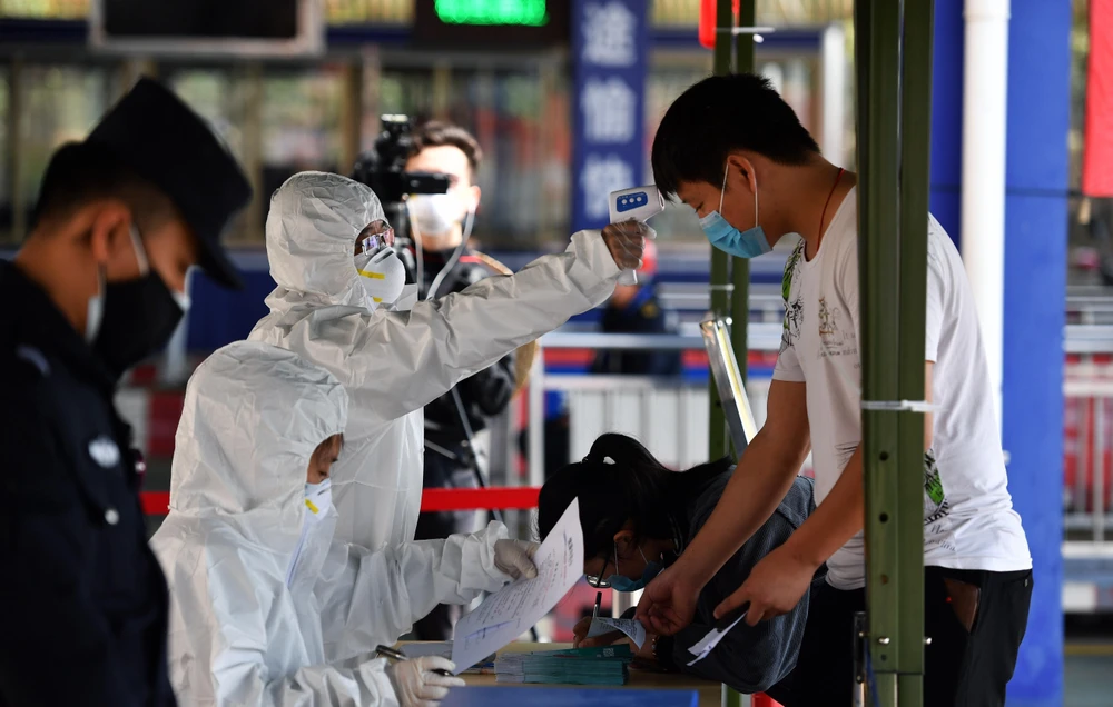 Nhân viên y tế kiểm tra thân nhiệt cho người dân tại thành phố Trạm Giang, tỉnh Quảng Đông, Trung Quốc, ngày 6/2/2020. (Ảnh: THX/TTXVN)