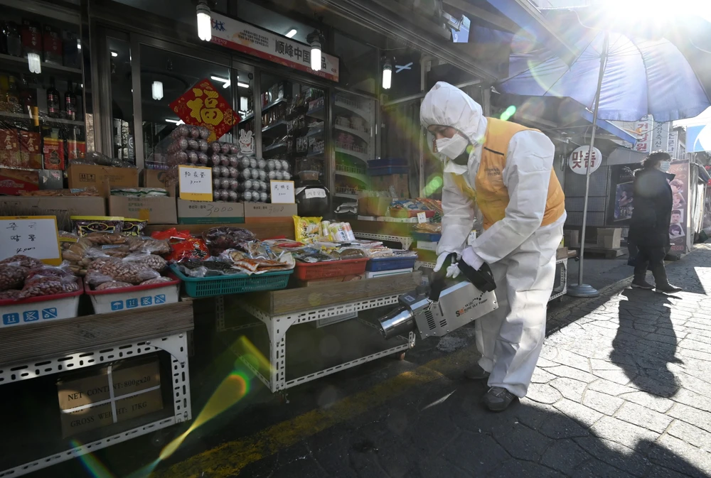 Phun thuốc khử trùng nhằm ngăn chặn sự lây lan của COVID-19 tại khu chợ ở Seoul, Hàn Quốc, ngày 5/2. (Ảnh: AFP/TTXVN)