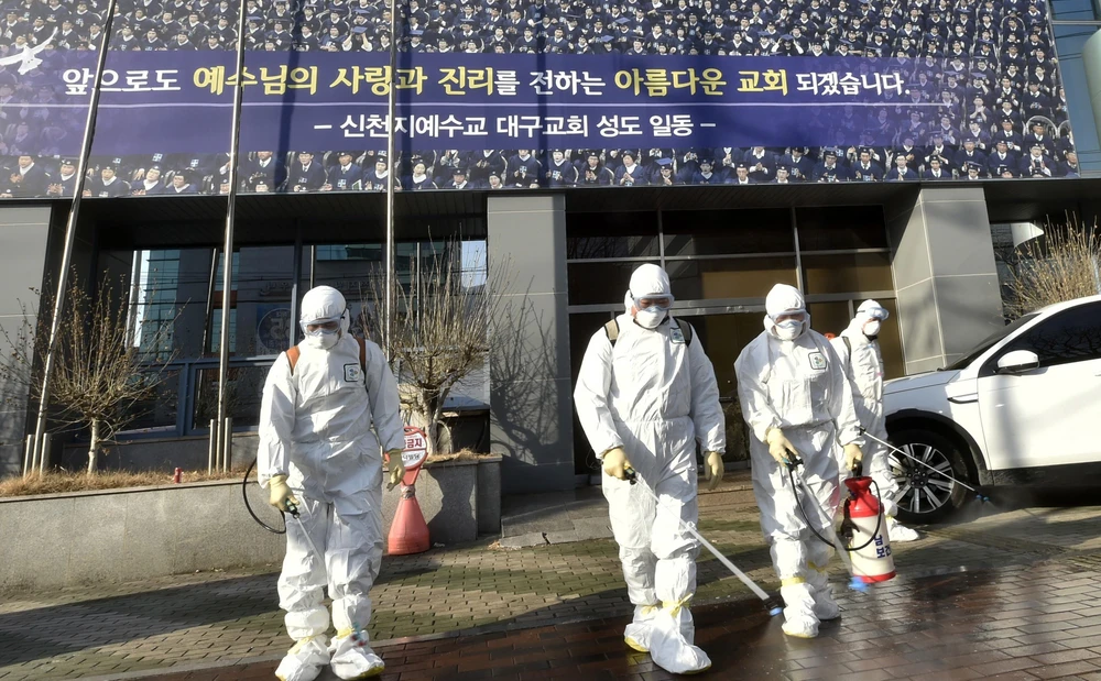 Nhân viên y tế phun thuốc khử chùng ngăn chặn sự lây lan của dịch bệnh COVID-19 tại Daegu, Hàn Quốc ngày 19/2. (Ảnh: AFP/TTXVN)