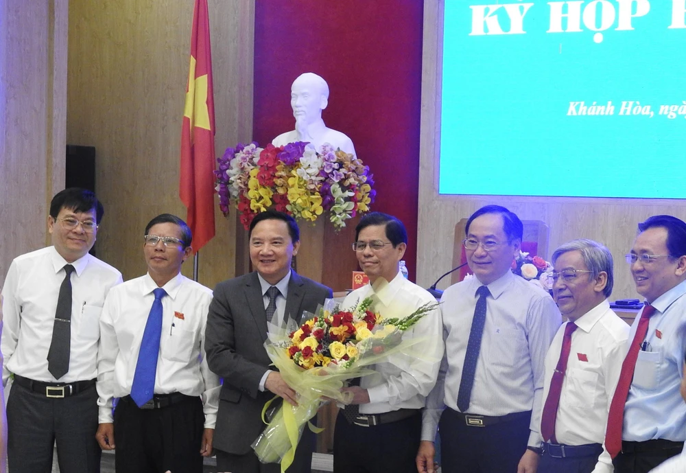 Lãnh đạo tỉnh Khánh Hòa tặng hoa, chúc mừng ông Nguyễn Tấn Tuân (giữa) sau khi được bầu giữ chức vụ Chủ tịch UBND tỉnh. (Ảnh: Tiên Minh/TTXVN)