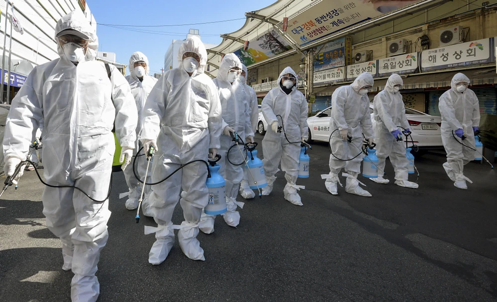 Nhân viên y tế phun thuốc khử trùng một khu chợ ở thành phố Daegu, Hàn Quốc ngày 23/2. (Ảnh: THX/TTXVN)