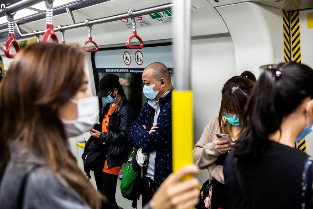 Người dân đeo khẩu trang phòng lây nhiễm COVID-19 trên tàu điện ngầm ở Hong Kong, Trung Quốc. (Ảnh: AFP/TTXVN)