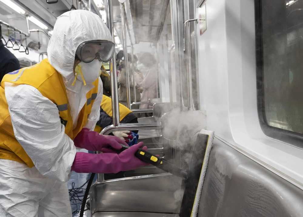 Nhân viên khử trùng tàu điện ngầm tại Seoul, Hàn Quốc, nhằm ngăn chặn sự lây lan của COVID-19 ngày 11/3. (Ảnh: THX/TTXVN)