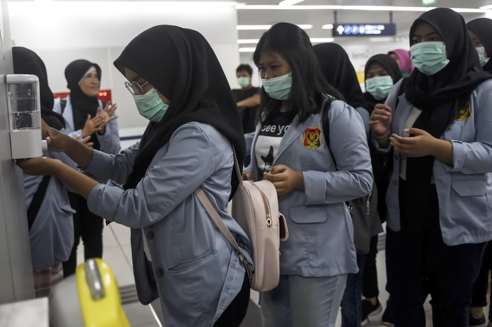 Sinh viên Indonesia đeo khẩu trang và sát khuẩn tay nhằm ngăn chặn sự lây lan của dịch COVID-19. (Ảnh: THX/TTXVN)
