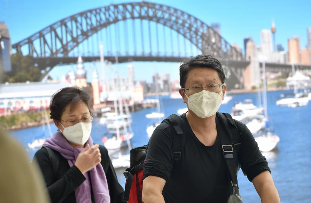 Hành khách đeo khẩu trang phòng lây nhiễm COVID-19 tại sân bay ở Sydney, Australia. (Ảnh: AFP/TTXVN)