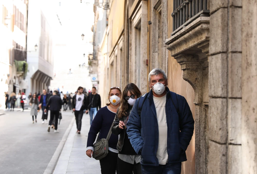 Người dân đeo khẩu trang để phòng tránh lây nhiễm COVID-19 tại Rome, Italy. (Ảnh: THX/TTXVN)
