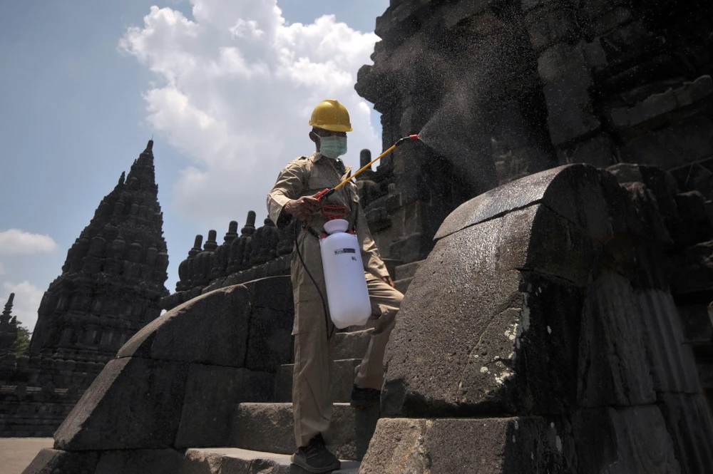 Nhân viên phun thuốc khử trùng tại một ngôi đền ở Trung Java, Indonesia. (Ảnh: THX/TTXVN)
