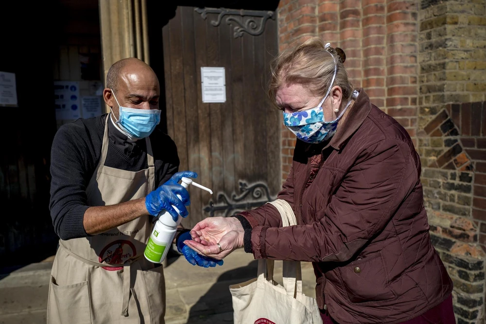 Người dân xịt khử khuẩn nhằm ngăn chặn sự lây lan của dịch COVID-19 ở London, Anh. (Ảnh: THX/TTXVN)