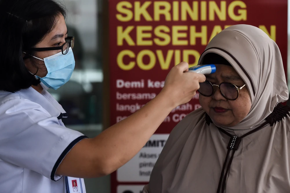 Kiểm tra thân nhiệt của khách tới thăm nhằm ngăn chặn lây lan dịch COVID-19 tại bệnh viện Siloam ở Jakarta. (Ảnh: THX/TTXVN)