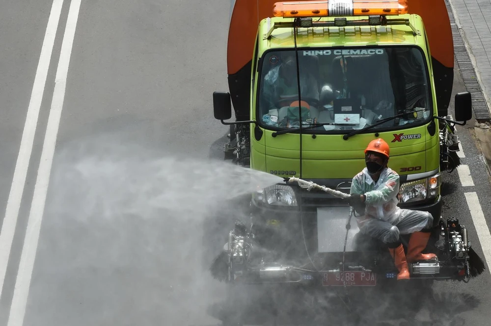 Phun khử trùng đường phố nhằm ngăn chặn sự lây lan của dịch COVID-19 tại Jakarta, Indonesia. (Ảnh: THX/TTXVN)