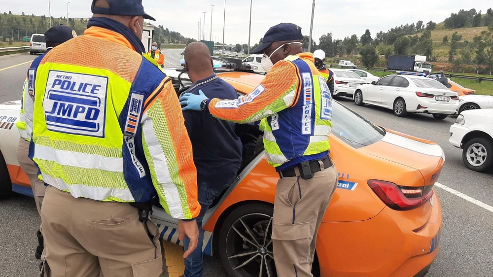 Cảnh sát bắt giữ một người dân chống lại quy định luật phong tỏa tại khu vực Diepkloof, cách thủ đô Pretoria 70 km về phía Nam. (Ảnh: TTXVN phát)