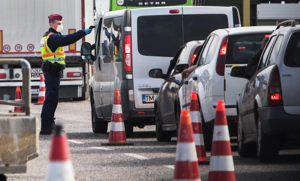 Cảnh sát Hungary kiểm tra thân nhiệt của tài xế tại khu vực cửa khẩu giữa Hungary-Áo, nhằm ngăn chặn sự lây lan của dịch COVID-19. (Ảnh: AFP/TTXVN)