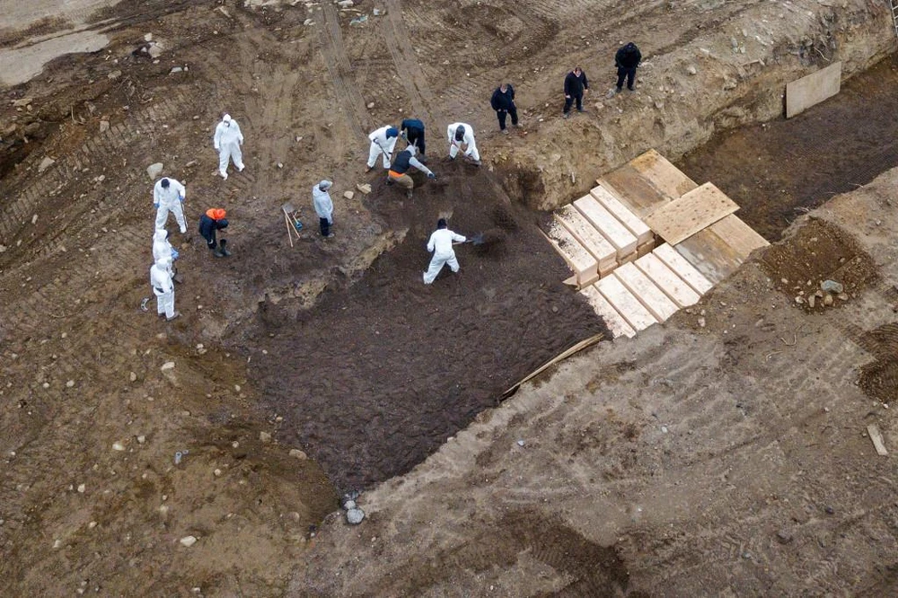 Công nhân mặc đồ bảo hộ chôn cất người chết vì COVID-19 trên đảo Hart. (Nguồn: Reuters)