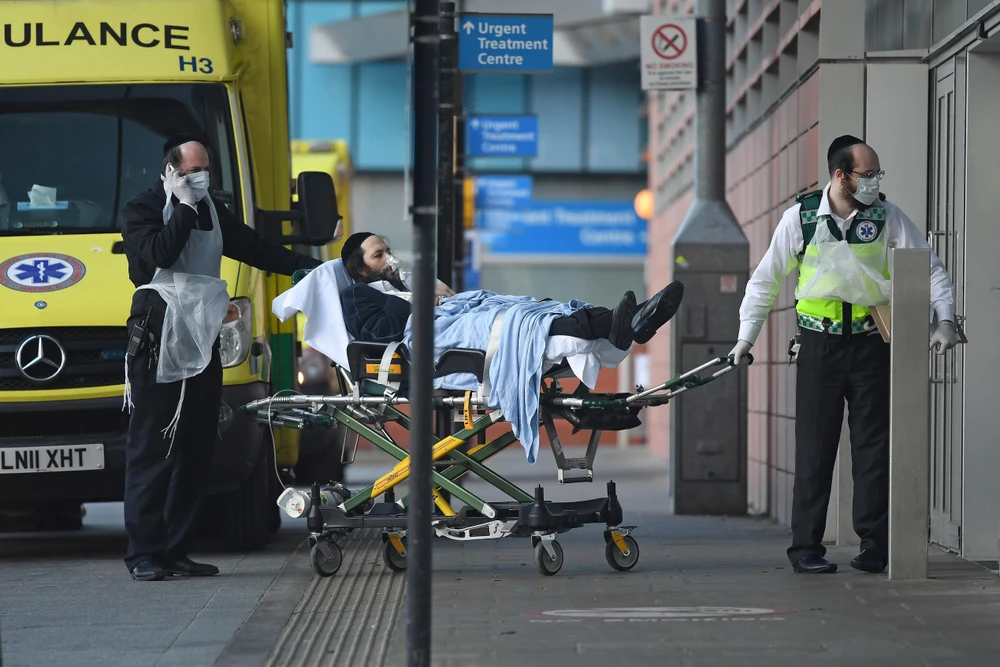 Chuyển bệnh nhân nhiễm COVID-19 tới bệnh viện ở London, Anh. (Ảnh: AFP/TTXVN)