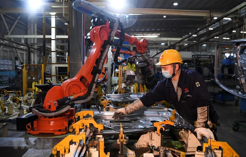 Công nhân làm việc bên trong một nhà máy ở Du Bắc, tỉnh Trùng Khánh, Trung Quốc ngày 11/3/2020. (Ảnh: THX/TTXVN)