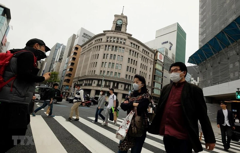 Người dân Nhật Bản đeo khẩu trang phòng tránh lây nhiễm COVID-19. (Ảnh: AFP/TTXVN)