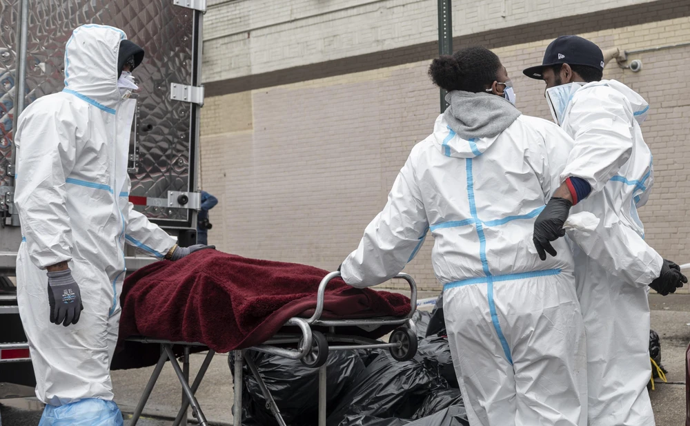 Nhân viên y tế chuyển thi thể bệnh nhân mắc COVID-19 tới nhà tang lễ ở Brooklyn, New York, Mỹ. (Ảnh: AFP/TTXVN)