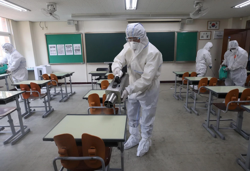 Nhân viên kiểm dịch phun khử trùng một lớp học ở Seoul, Hàn Quốc. (Ảnh: Yonhap/TTXVN)