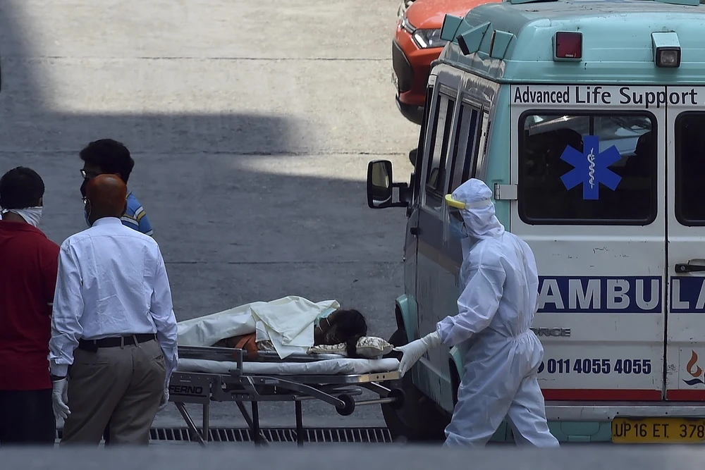 Nhân viên y tế chuyển bệnh nhân nghi mắc COVID-19 từ xe cứu thương vào một bệnh viện ở New Delhi, Ấn Độ. (Ảnh: AFP/TTXVN)