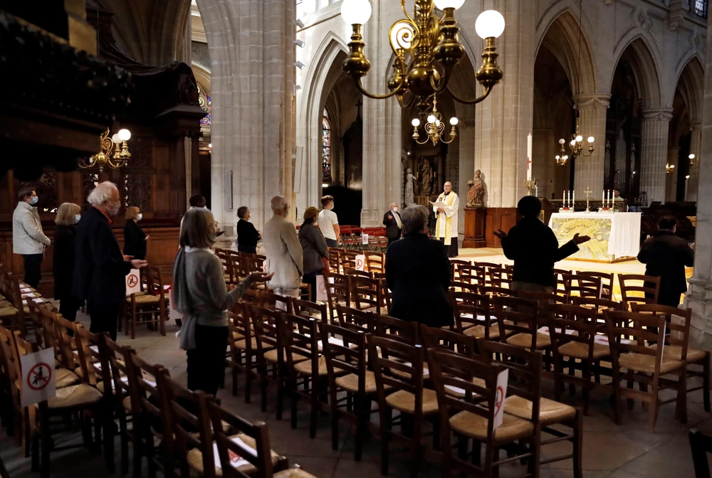 Các tín đồ Thiên chúa giáo cầu nguyện tại một nhà thờ ở Paris, Pháp ngày 24/5. (Ảnh: AFP/TTXVN)