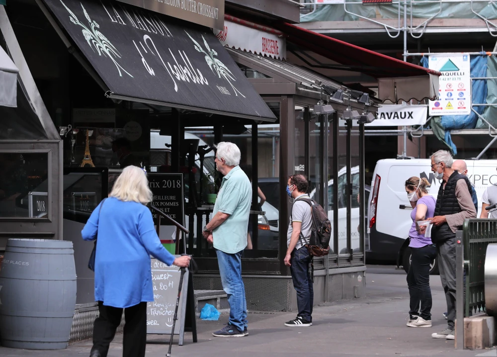 Người dân xếp hàng bên ngoài một hiệu bánh ở Paris, Pháp ngày 22/5. (Ảnh: THX/TTXVN)