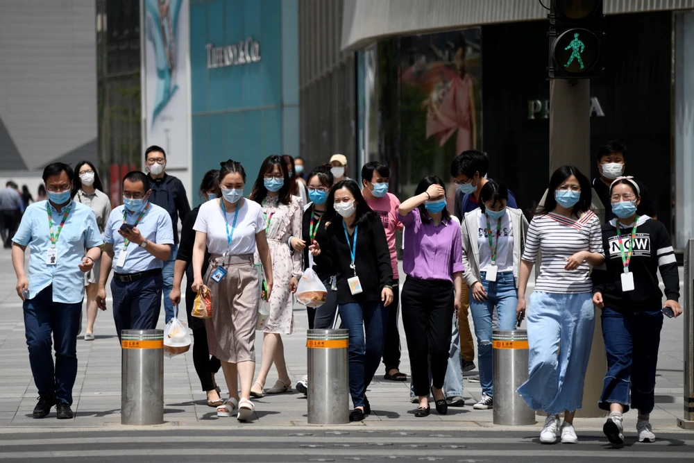 Người dân đeo khẩu trang phòng dịch COVID-19 tại Bắc Kinh, Trung Quốc ngày 20/5. (Ảnh: AFP/TTXVN)