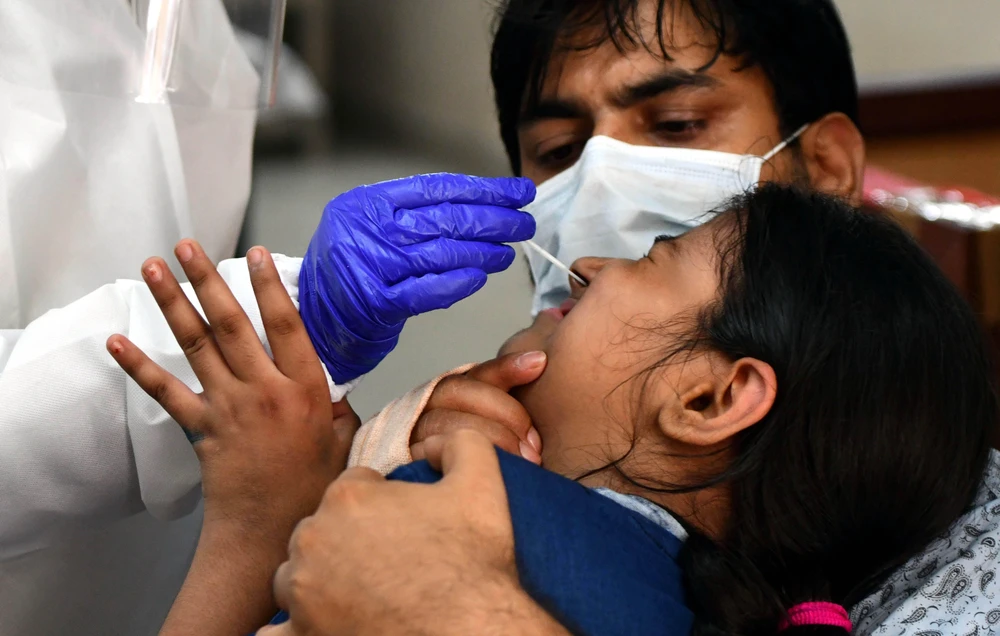 Nhân viên y tế lấy mẫu dịch xét nghiệm COVID-19 cho người dân tại New Delhi, Ấn Độ. (Ảnh: THX/TTXVN)