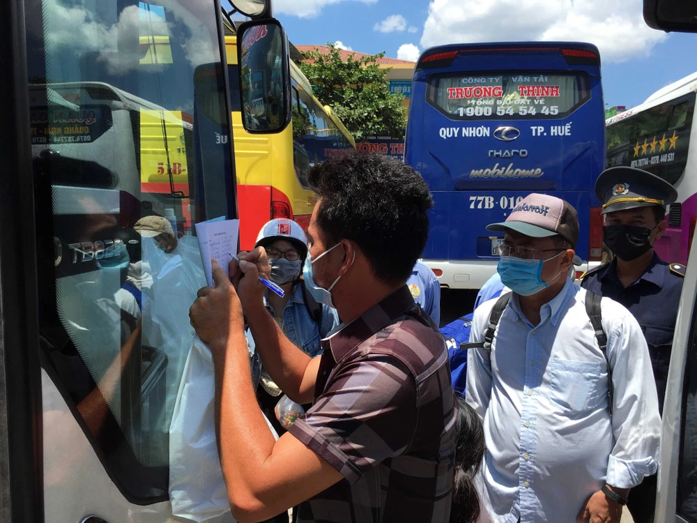 Hành khách đi trên những phương tiện giao thông khai báo thông tin cá nhân tại Bến xe phía Nam tỉnh Thừa Thiên-Huế. (Ảnh: Đỗ Trưởng/TTXVN)