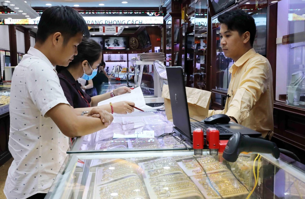 Khách mua bán vàng tại Công ty Kinh doanh vàng bạc Bảo Tín Minh Châu. (Ảnh: Trần Việt - TTXVN)