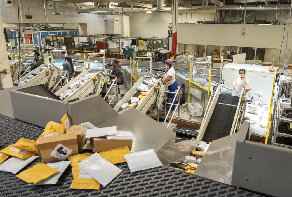 Nhân viên chuyển bưu phẩm tại Dịch vụ Bưu điện Mỹ ở Los Angeles, bang California, Mỹ. (Ảnh: AFP/TTXVN)