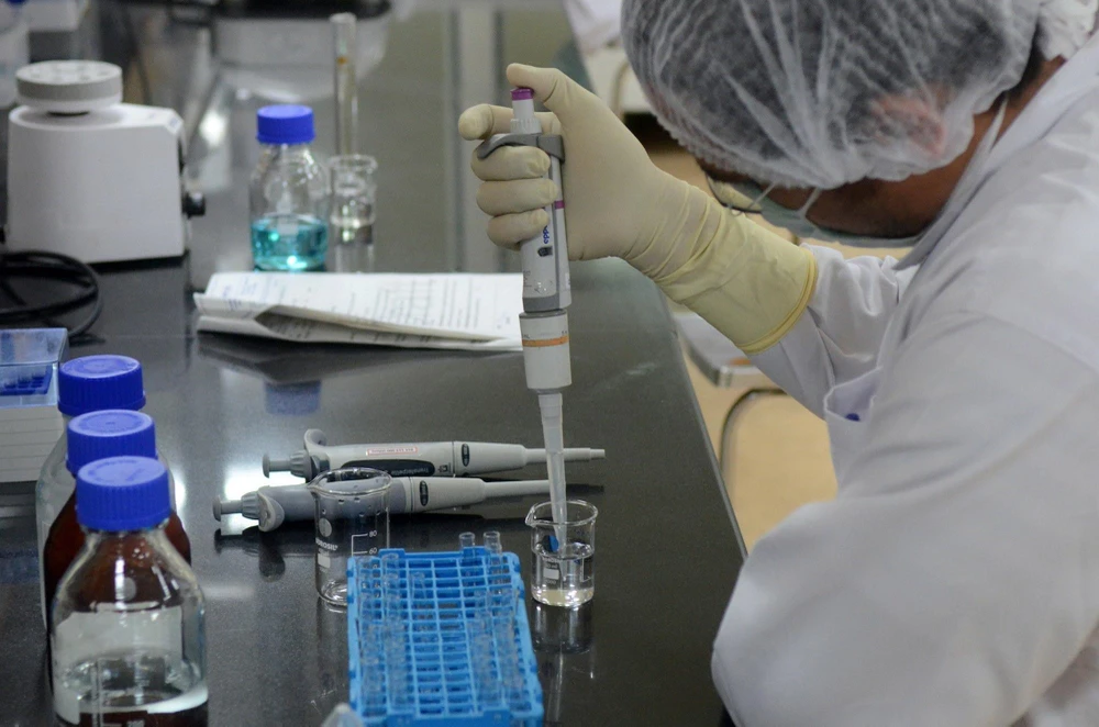 Nghiên cứu viên bào chế vắcxin phòng COVID-19 tại phòng thí nghiệm của Viện sản xuất vaccine lớn nhất Ấn Độ ở Pune. (Ảnh: Reuters/TTXVN)