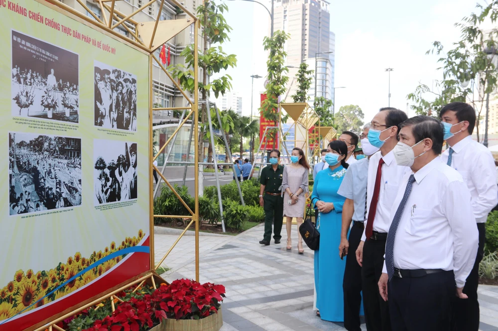 Lãnh đạo Thành phố Hồ Chí Minh tham quan triển lãm ảnh. (Ảnh: Thu Hương/TTXVN)